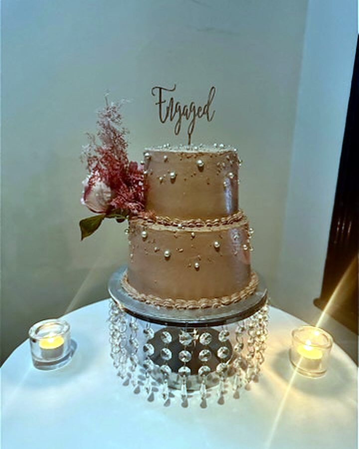Two-tier engagement cake on a crystal stand