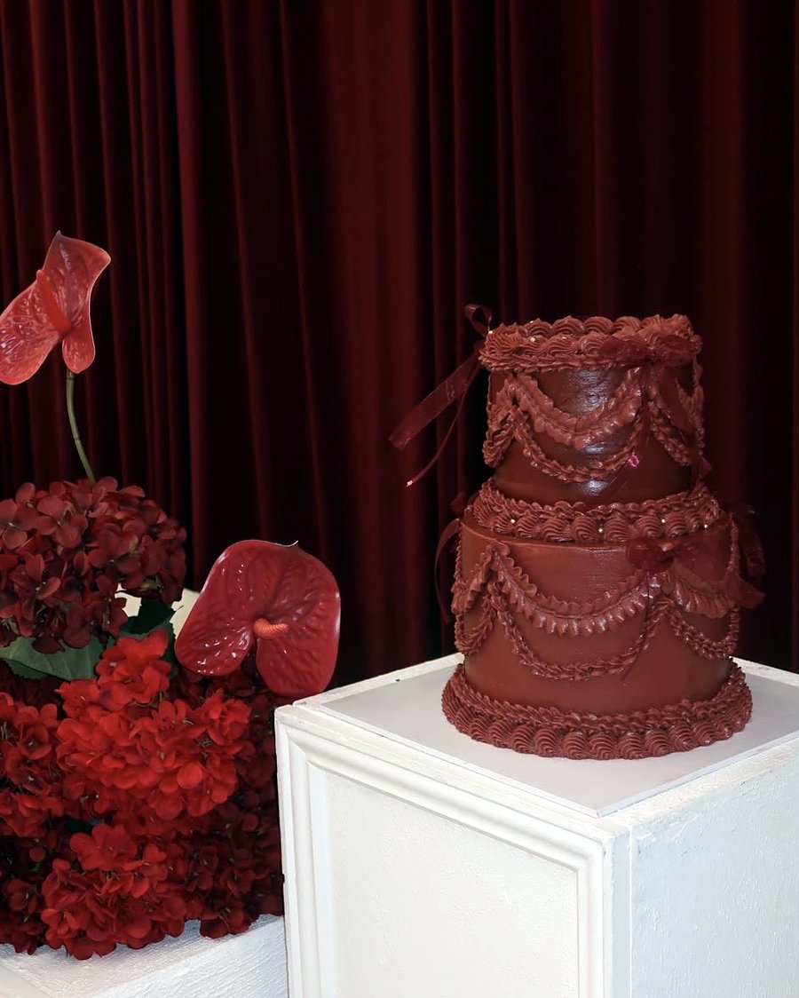 Deep red two-tier vintage cake styled for an event