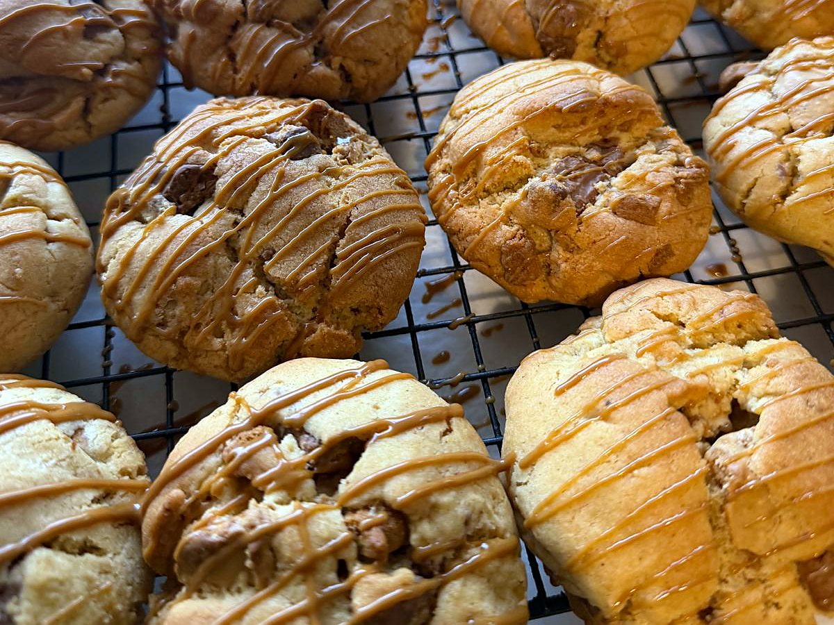 Caramel-drizzled choc-chunk cookies on a cooling rack