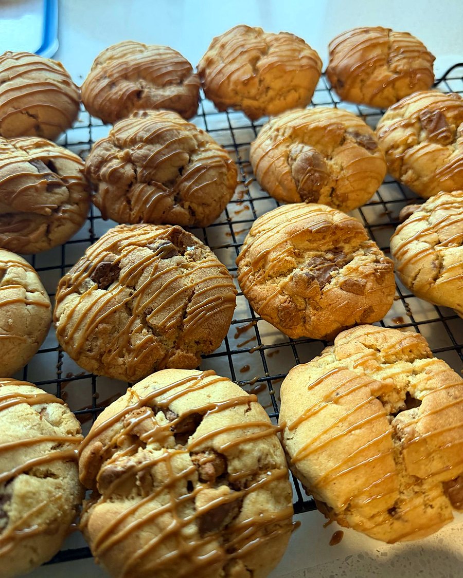 Caramel-drizzled choc-chunk cookies on a cooling rack